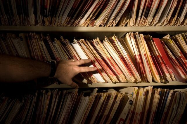 photo of patient records and suspicious hand